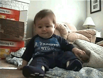GIF of baby laughing so hard he falls over